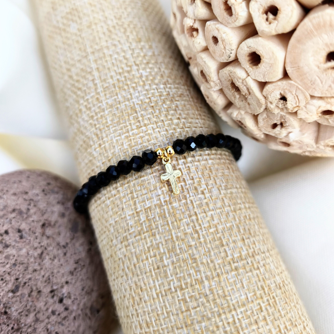 Pulsera con cristales negros y cruz bañada en oro 24k