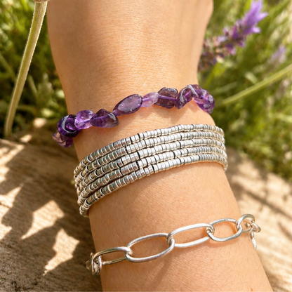 detalle pulsera amatista natural piedras violetas en muñeca al aire libre
