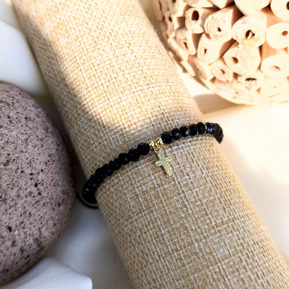 Pulsera con cristales negros y cruz bañada en oro 24k