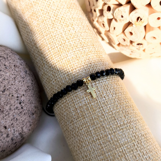 Pulsera con cristales negros y cruz bañada en oro 24k
