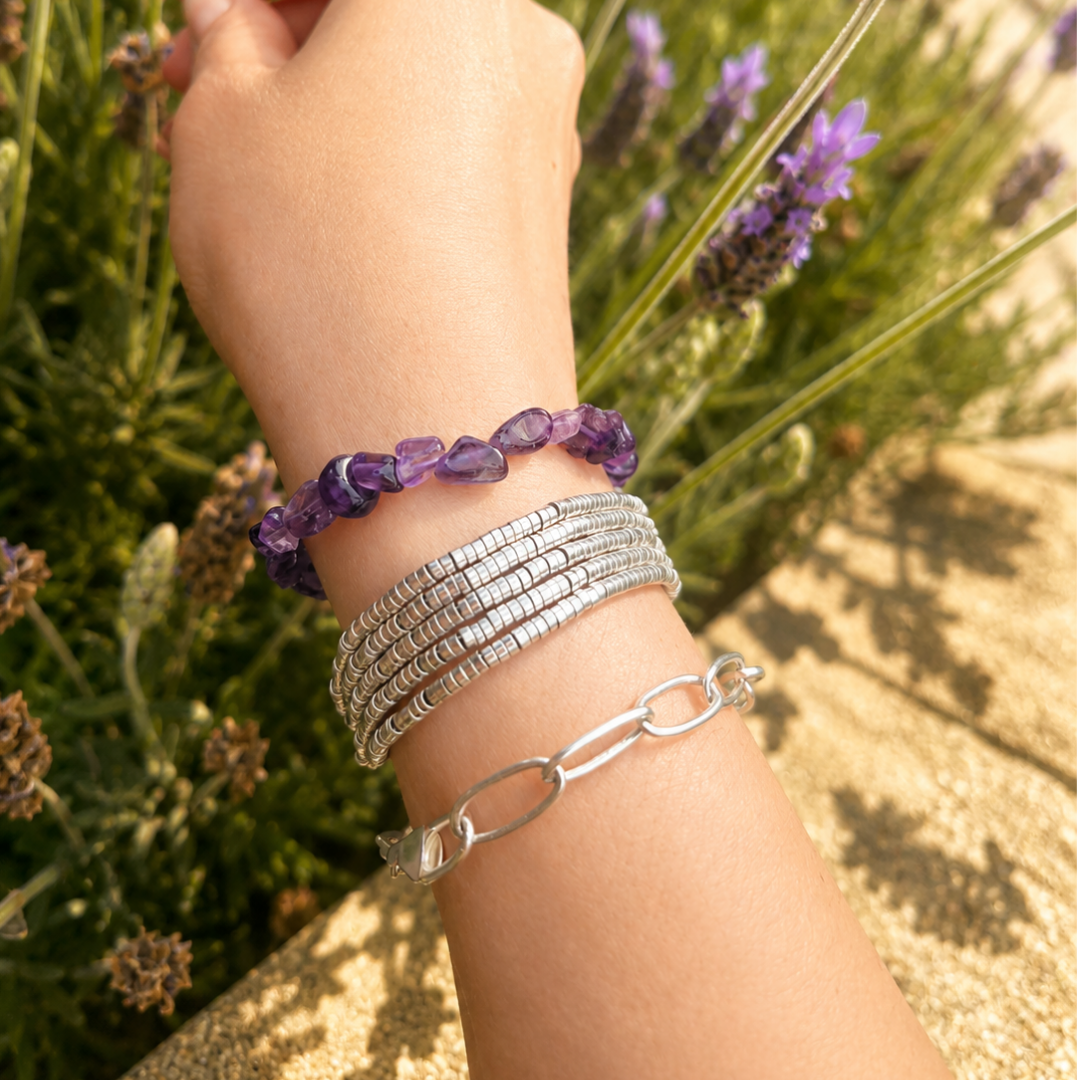 pulsera de piedra amatista natural usada en muñeca combinada con otras pulseras