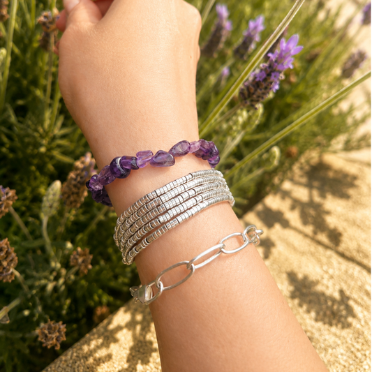 pulsera de piedra amatista natural usada en muñeca combinada con otras pulseras